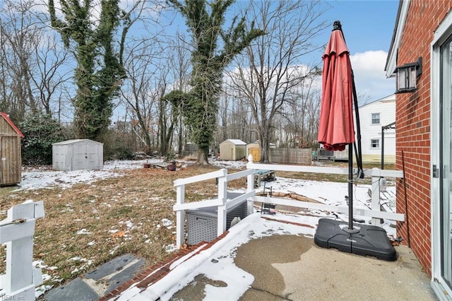 yard covered in snow with a storage unit