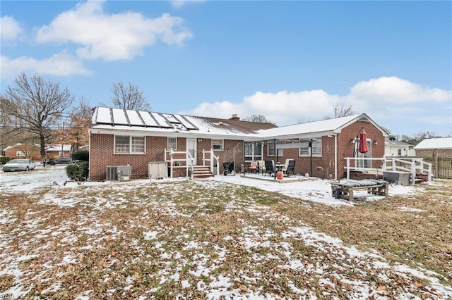 snow covered property with central AC