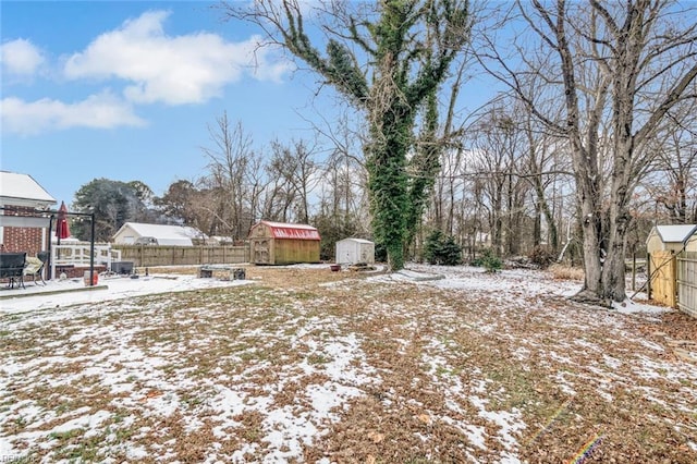 snowy yard featuring a storage shed