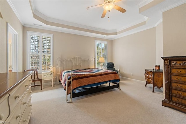 bedroom featuring light carpet, a tray ceiling, ornamental molding, and ceiling fan