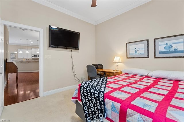 carpeted bedroom with ornamental molding and ceiling fan