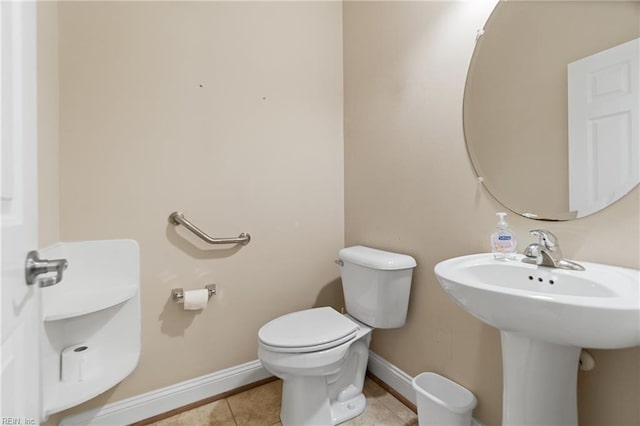 bathroom with sink, toilet, and tile patterned flooring