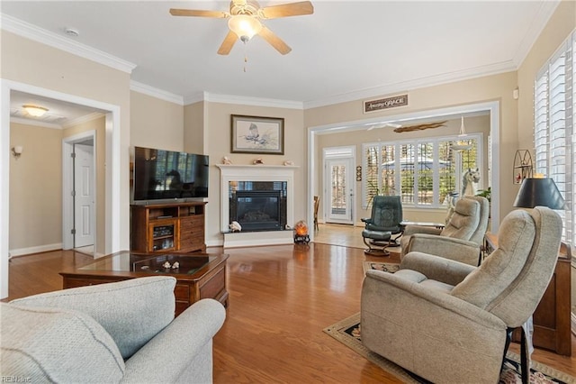 living room with hardwood / wood-style floors, ornamental molding, and ceiling fan