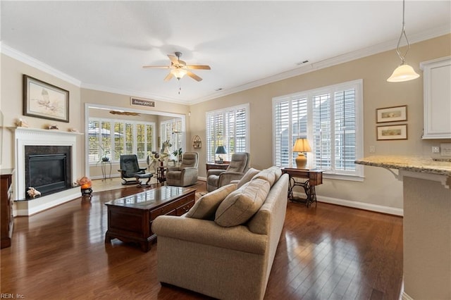 living room featuring crown molding, a premium fireplace, dark hardwood / wood-style floors, and ceiling fan