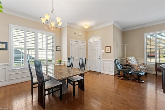 dining room featuring hardwood / wood-style flooring, ornamental molding, and a chandelier