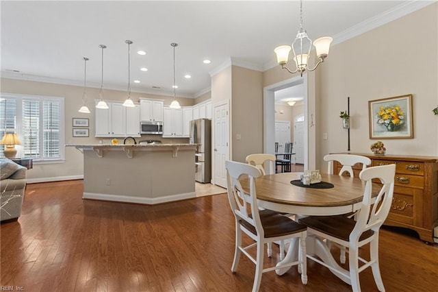 dining space with an inviting chandelier, ornamental molding, and dark hardwood / wood-style floors