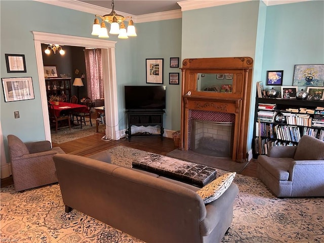 living room with crown molding, a chandelier, and a tiled fireplace