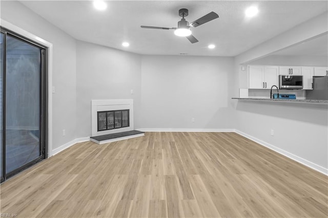 unfurnished living room featuring light hardwood / wood-style floors and ceiling fan