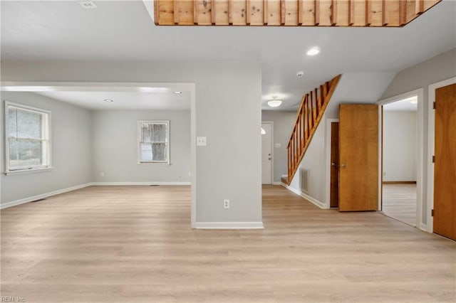 unfurnished living room with a wealth of natural light and light hardwood / wood-style flooring