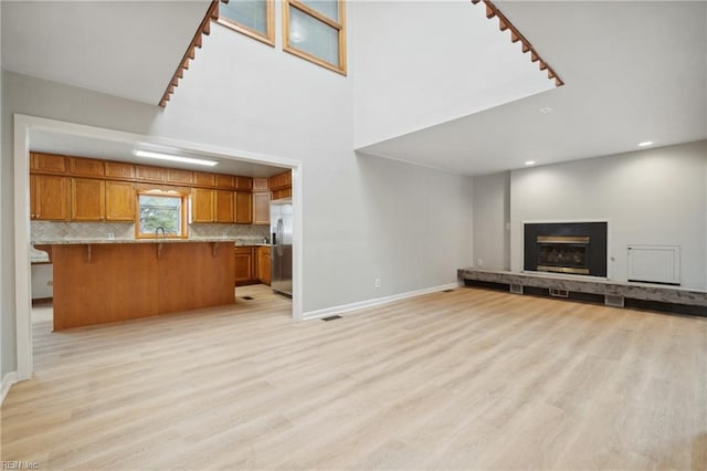 unfurnished living room with sink and light hardwood / wood-style floors