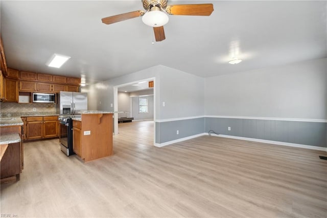 kitchen featuring backsplash, a kitchen breakfast bar, a center island, light hardwood / wood-style floors, and stainless steel appliances