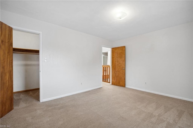 unfurnished bedroom featuring light colored carpet, a spacious closet, and a closet