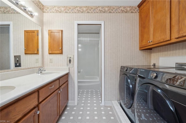 laundry area featuring light tile patterned flooring, separate washer and dryer, and sink