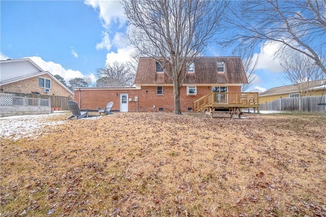 back of property with an outdoor fire pit and a deck