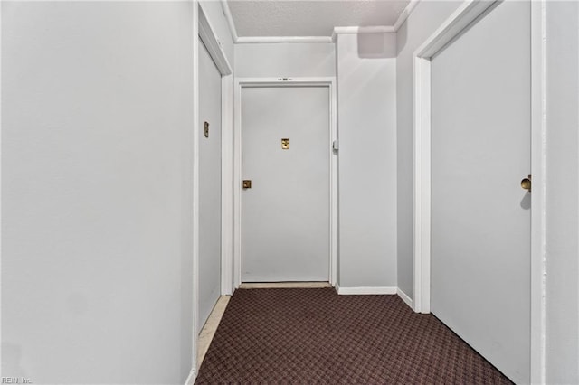 corridor featuring dark carpet and a textured ceiling