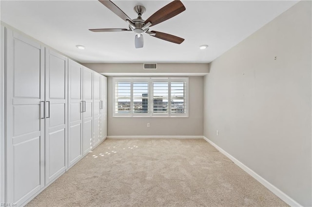 unfurnished bedroom featuring light carpet and ceiling fan