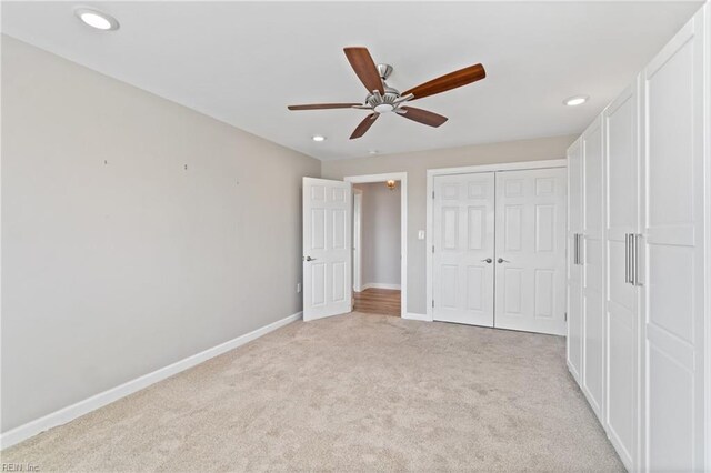 unfurnished bedroom featuring light colored carpet, ceiling fan, and a closet