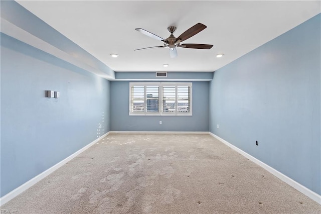 spare room featuring light colored carpet and ceiling fan