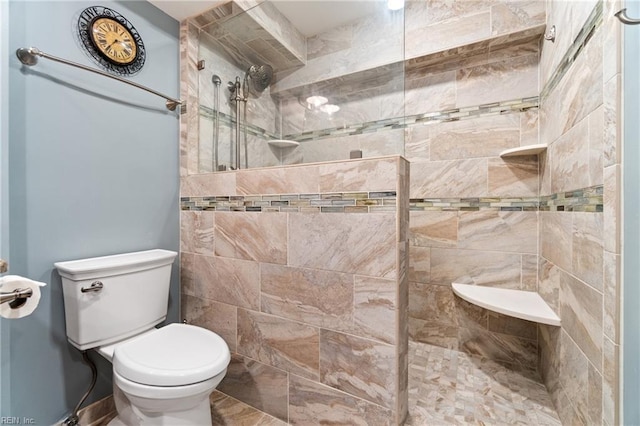 bathroom featuring toilet and tiled shower