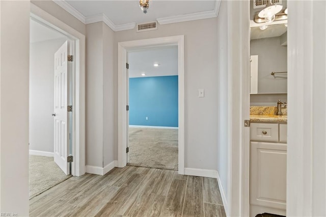 hallway featuring ornamental molding and light wood-type flooring