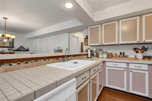 kitchen featuring an inviting chandelier, tile counters, sink, and hanging light fixtures