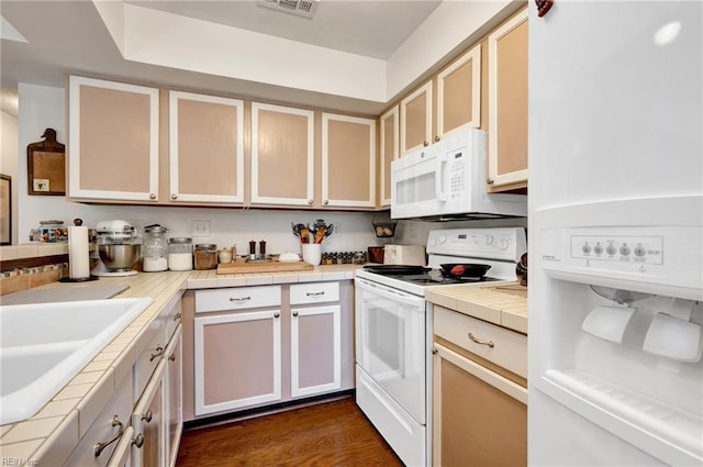 kitchen featuring dark hardwood / wood-style flooring, sink, white appliances, and tile countertops