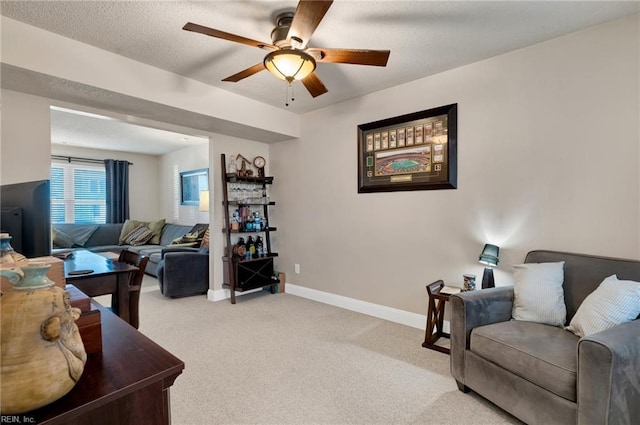 carpeted living room with ceiling fan