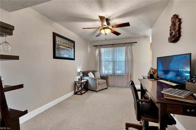 carpeted home office featuring ceiling fan and a textured ceiling