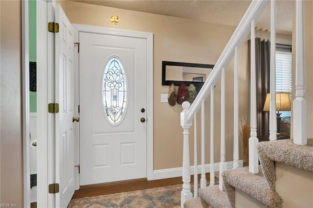 foyer with dark hardwood / wood-style floors and a textured ceiling