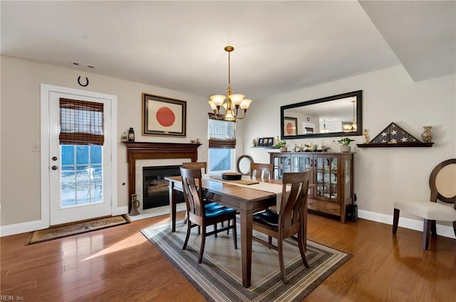 dining room with hardwood / wood-style floors, a notable chandelier, and a healthy amount of sunlight