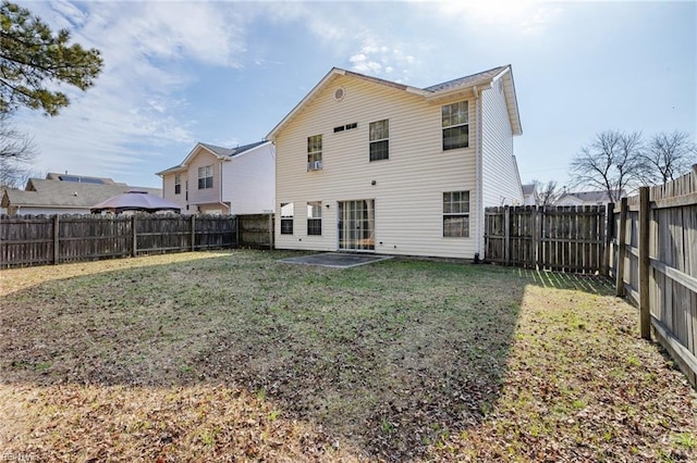 back of house with a patio and a lawn