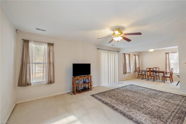 carpeted living room featuring ceiling fan