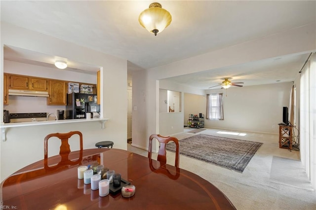 carpeted dining space featuring ceiling fan