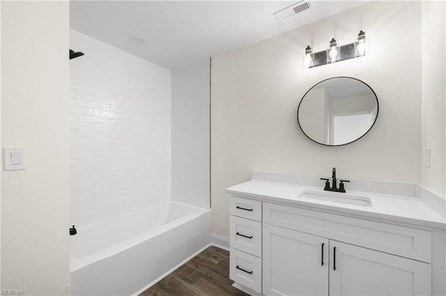 bathroom featuring tiled shower / bath, hardwood / wood-style floors, and vanity