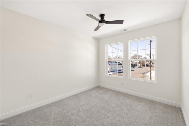 empty room featuring ceiling fan and carpet