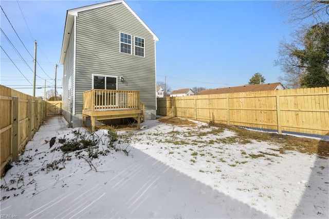 snow covered house with a deck