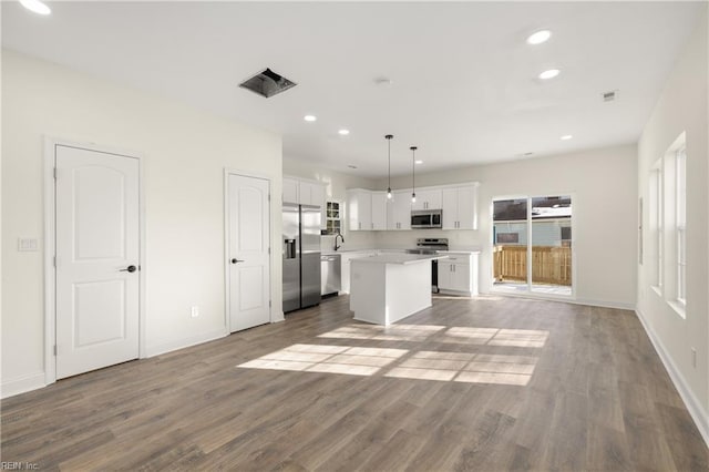 kitchen with stainless steel appliances, hanging light fixtures, a center island, and white cabinets