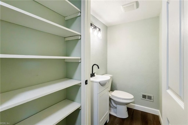 bathroom featuring vanity, hardwood / wood-style floors, and toilet