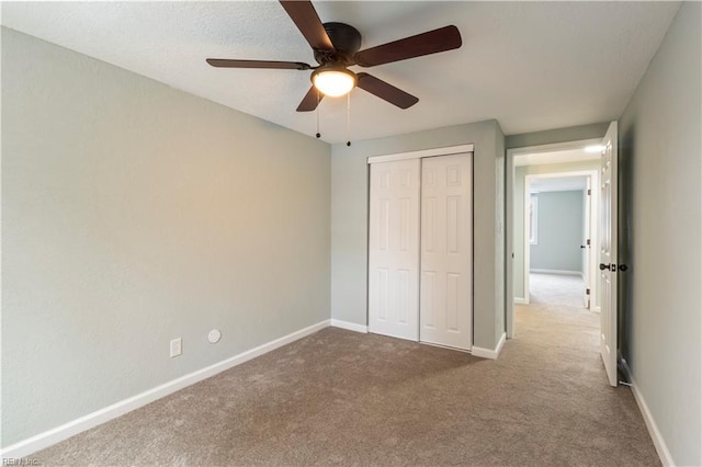 unfurnished bedroom with carpet, ceiling fan, and a closet