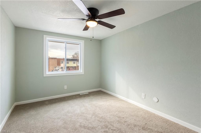 spare room with ceiling fan and carpet