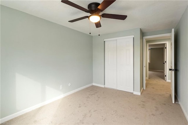 unfurnished bedroom with light carpet, a closet, and ceiling fan