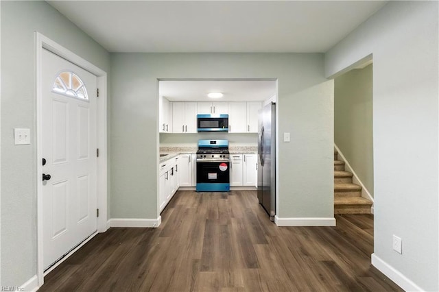 kitchen with white cabinetry, stainless steel appliances, and dark wood-type flooring