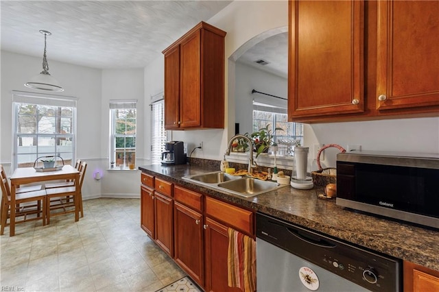 kitchen with appliances with stainless steel finishes, sink, and pendant lighting