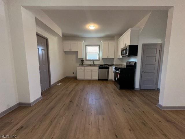 kitchen featuring sink, dark wood-type flooring, white cabinets, and appliances with stainless steel finishes