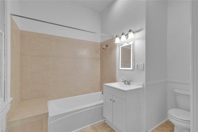 full bathroom with vanity, tiled shower / bath, tile patterned floors, and toilet