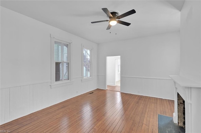 unfurnished living room with hardwood / wood-style flooring and ceiling fan