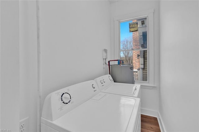 laundry room featuring hardwood / wood-style flooring, gas water heater, and washing machine and dryer