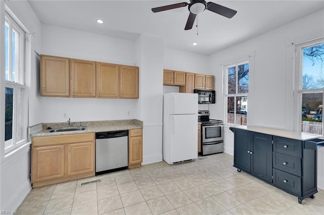 kitchen featuring light tile patterned flooring, appliances with stainless steel finishes, sink, and ceiling fan