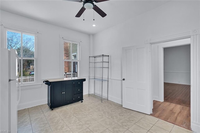 interior space featuring light tile patterned floors and ceiling fan