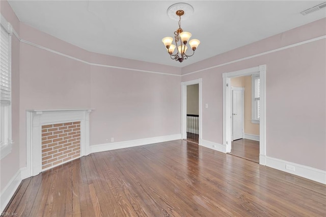 unfurnished living room with wood-type flooring and a notable chandelier